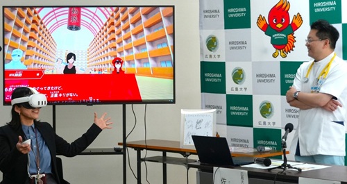 Dr. Saeki (right) explains Cells at Work! VR to reporters at the press briefing